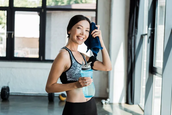 Chica Feliz Sosteniendo Botella Deporte Mientras Limpia Sudor Con Toalla — Foto de Stock