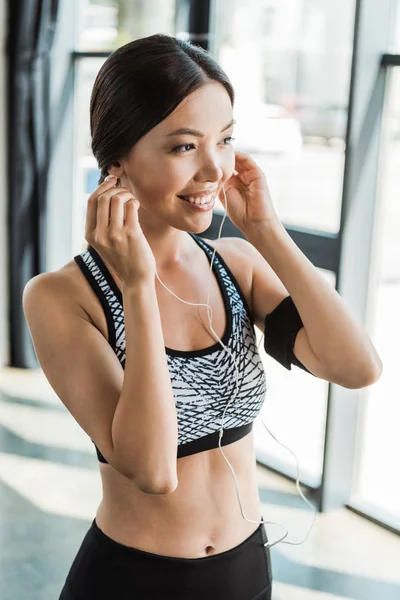 Positive Sportive Woman Holding Earphones Gym — Stock Photo, Image