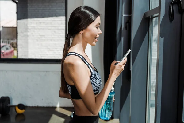 Side View Cheerful Sportswoman Holding Smartphone Sport Bottle — Stock Photo, Image