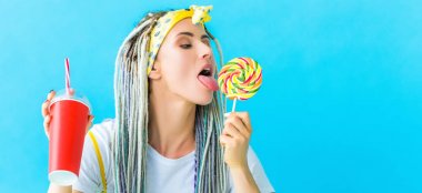 dreadlocks ve soda içecek turkuaz izole lolipop yalama ile kız panoramik çekim