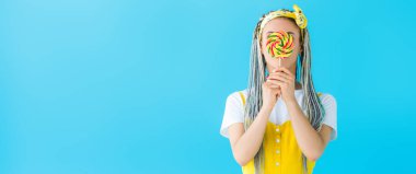 turkuaz izole lolipop ile yüz kapsayan dreadlocks ile kız panoramik çekim