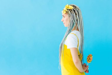 kopya alanı ile turkuaz izole lolipop tutan dreadlocks ile kız yan görünümü