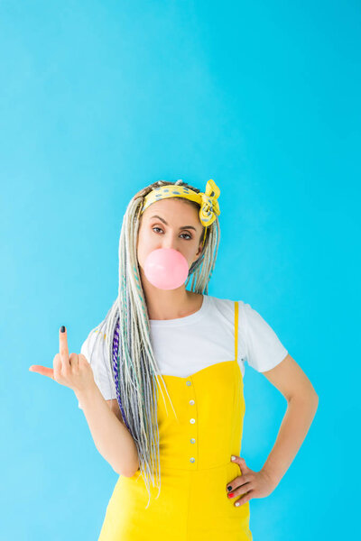 girl with dreadlocks blowing bubblegum and showing middle finger on turquoise