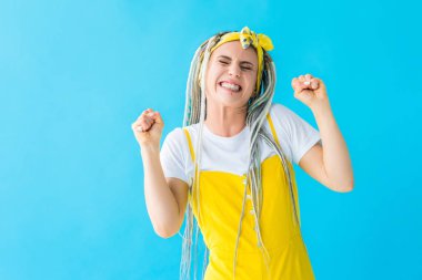 dreadlocks ile turkuaz izole sıkıştırılmış yumruklar ile tezahürat heyecanlı kız