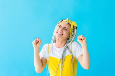 dreadlocks ile turkuaz izole sıkıştırılmış yumruklar ile tezahürat heyecanlı kız