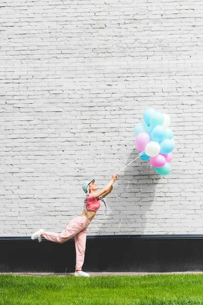 Gadis Bergaya Berpose Dengan Balon Dekoratif Dekat Dinding Bata — Stok Foto