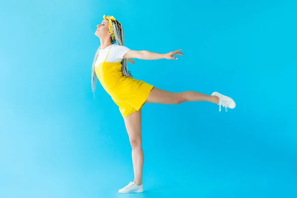 Glückliches Mädchen Mit Dreadlocks Mit Ausgestreckten Händen Und Bein Posiert — Stockfoto