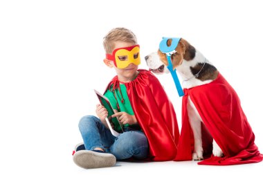 maske ve kırmızı kahraman cloacks beyaz dijital tablet ile oturan Anaokulu çocuk ve Beagle köpek
