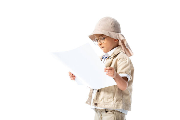 focused explorer child in glasses and hat looking at placard isolated on white