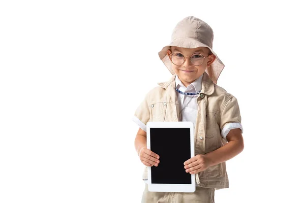 白で隔離された空白の画面を持つデジタルタブレットを保持する眼鏡と帽子で笑顔の探検家の子供 — ストック写真