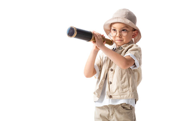 curious smiling explorer boy in glasses and hat holding spyglass isolated on white