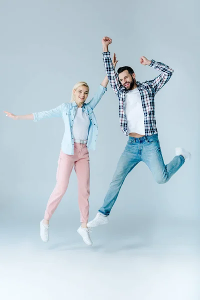 灰色にジャンプカジュアルな服で幸せな男と女の子 — ストック写真