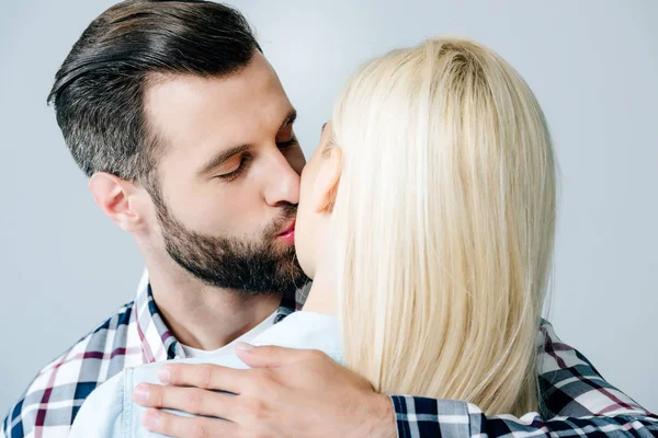 Pohledný Muž Líbání Objímající Dívku Izolovanou Šedé — Stock fotografie