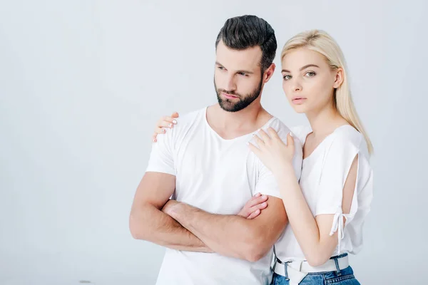 Hermosa Joven Abrazando Hombre Molesto Con Brazos Cruzados Aislados Gris — Foto de Stock