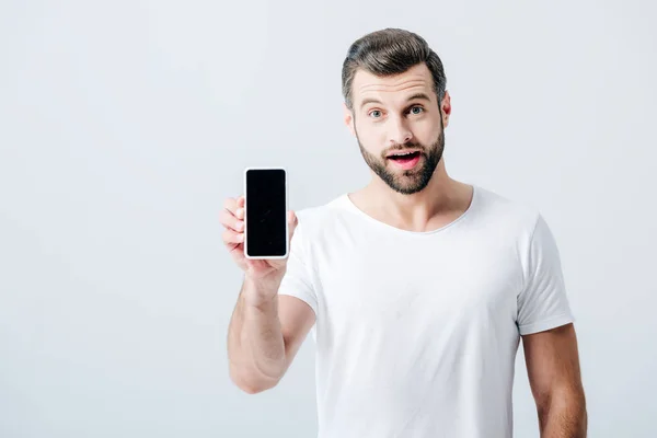Geschokt Man Toont Smartphone Met Blanco Scherm Geïsoleerd Grijs — Stockfoto