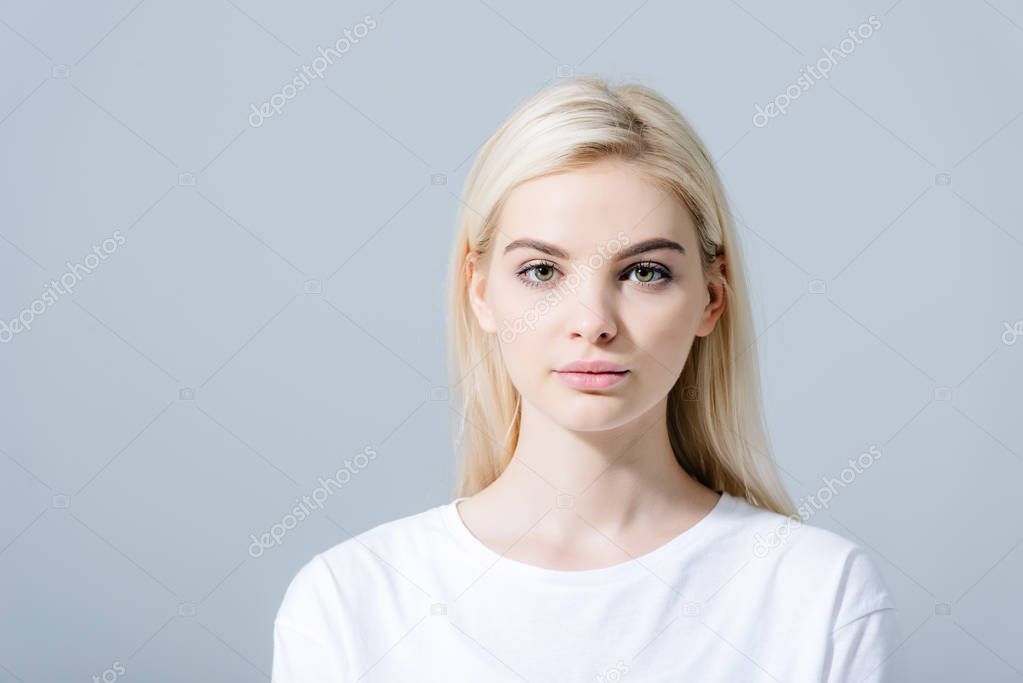 beautiful blonde girl looking at camera isolated on grey with copy space