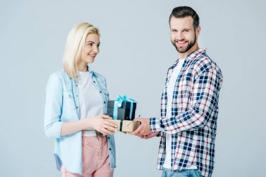 smiling man giving presents to beautiful girl isolated on grey clipart