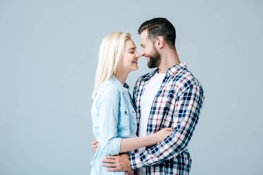 güzel genç çift sarılma ve birbirlerine gri izole bakarak