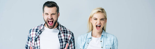 panoramic shot of man and woman shouting isolated on grey