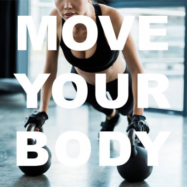 cropped view of girl in sportswear exercising with dumbbells near move your body letters  clipart