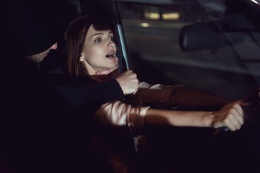 thief strangling beautiful frightened woman in automobile at night clipart