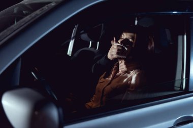 thief attacking beautiful frightened woman in automobile at night clipart