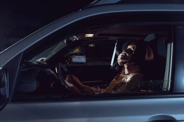 thief attacking beautiful frightened woman in automobile at night clipart