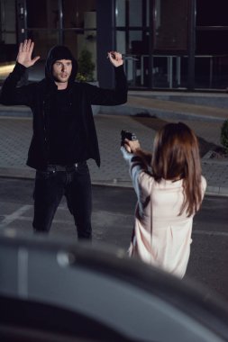 kadın otoparkta gece havada elleri ile hırsız silah işaret