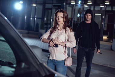 otoparkta gece hırsız ve araba yakın silah ile kadın