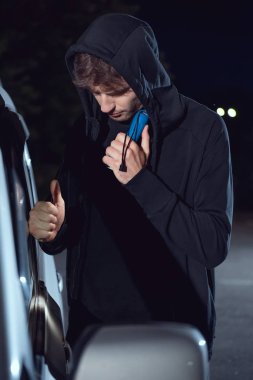 el feneri ve levye ile hoodie davetsiz arabada hırsız