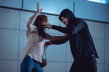 woman defending herself from attacking thief in underpass clipart