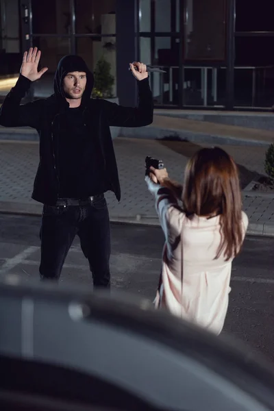 Woman Pointing Gun Thief Hands Air Night Parking Lot — Stock Photo, Image