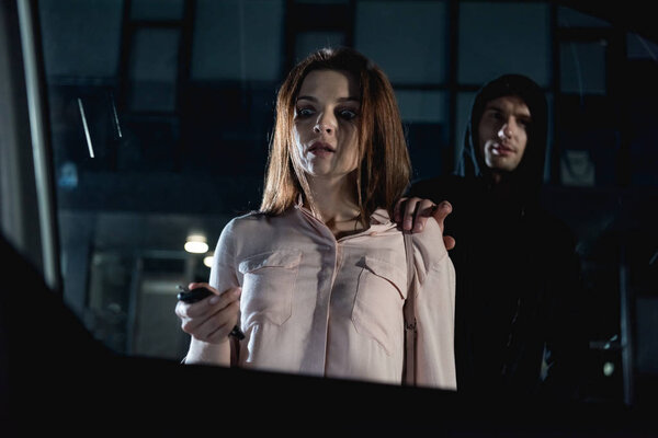 Вор нападает на испуганную женщину возле машины ночью
