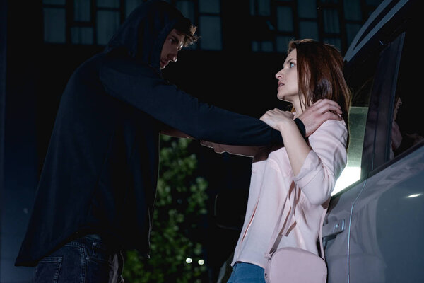 Вор нападает на испуганную женщину возле машины ночью
