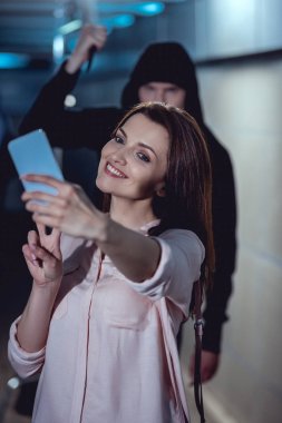 bıçak ile hırsız akıllı telefonda selfie alarak gülümseyen kadın saldıran