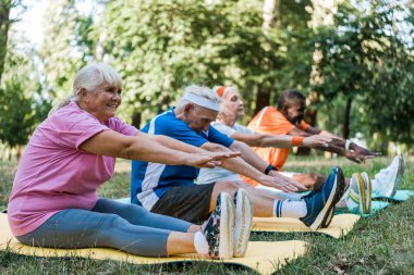 spor dansı spor da sportif emekli ve çok kültürlü erkek ve kadın seçici odak fitness paspaslar üzerinde egzersiz 