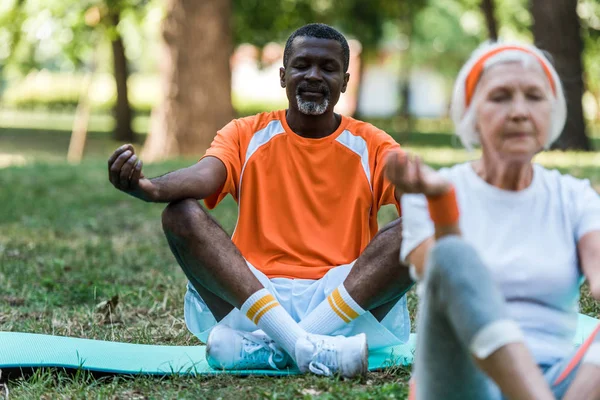 Selective Focus Retired African American Man Closed Eyes Sitting Crossed — Stock Photo, Image