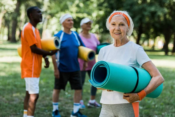 Selektiver Fokus Einer Glücklichen Rentnerin Mit Fitnessmatte Die Neben Multikulturellen — Stockfoto