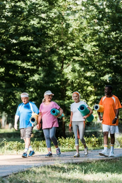 Enfoque Selectivo Pensionistas Mayores Multiculturales Que Sostienen Colchonetas Fitness Caminan — Foto de Stock