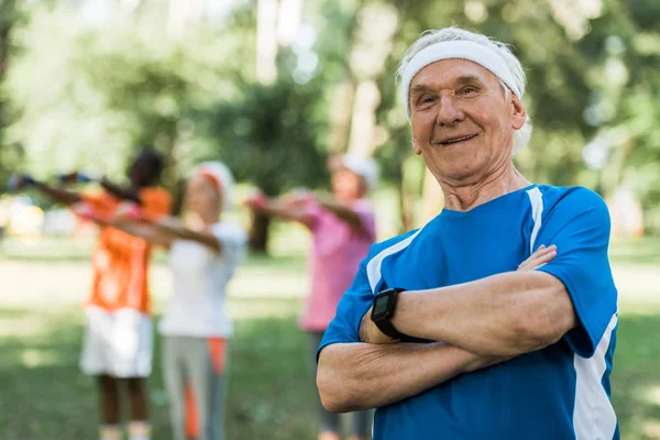 选择性的焦点快乐的老人站在交叉的手臂在公园 — 图库照片