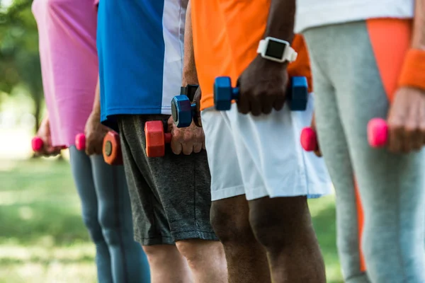 Vista Recortada Pensionistas Multiculturales Ropa Deportiva Sosteniendo Pesas Parque — Foto de Stock