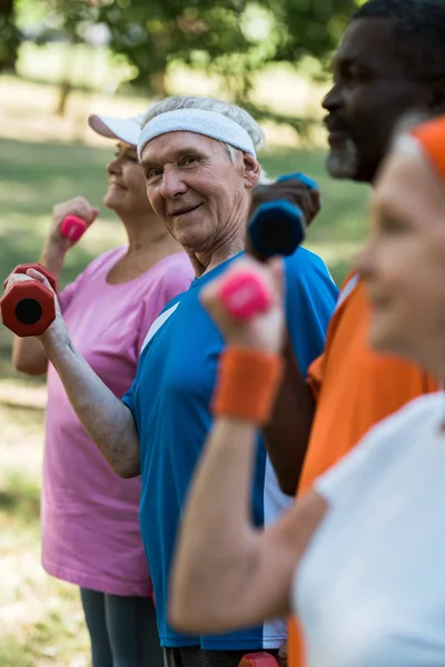 Selective Focus Cheerful Senior Man Looking Camera While Exercising Dumbbell — Stock Photo, Image