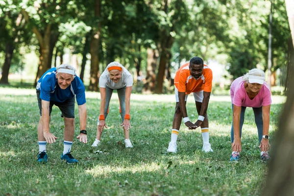 Selective Focus Happy Multicultural Pensioners Doing Stretching Exercise Grass — Stock Photo, Image
