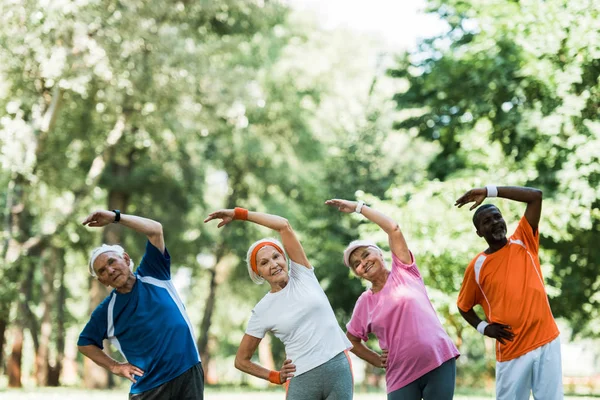 Vidám Multikulturális Nyugdíjas Férfiak Nők Állva Kezét Csípő Eközben Stretching — Stock Fotó