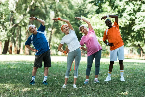 Vidám Multikulturális Nyugdíjas Férfiak Nők Állva Kezét Csípő Eközben Stretching — Stock Fotó