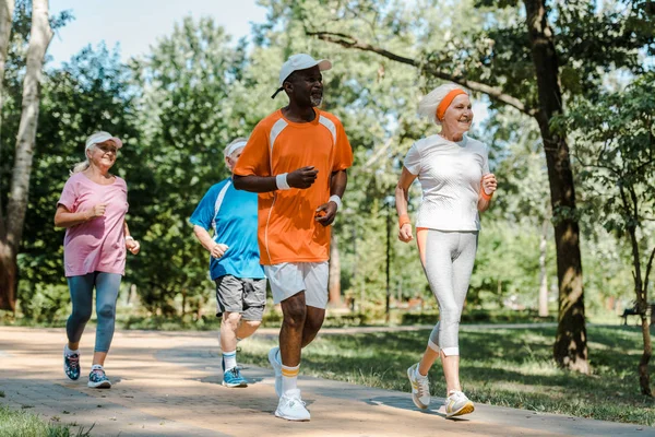 Fröhliche Multikulturelle Und Pensionierte Männer Und Frauen Die Park Laufen — Stockfoto