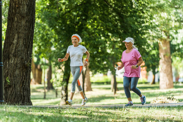 избирательный фокус веселые пожилые женщины в спортивной пробежки в парке
 