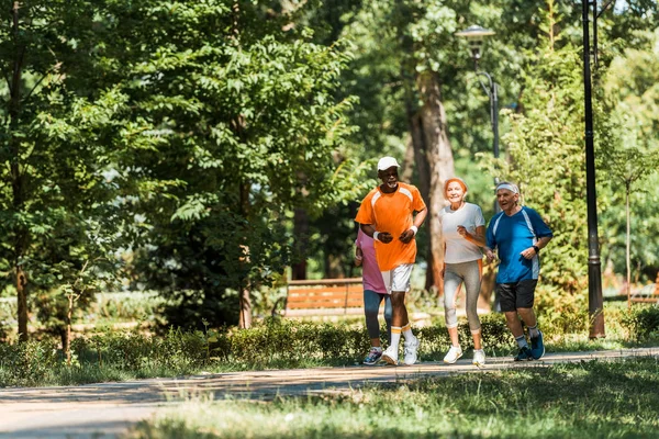 选择性焦点 多元文化 老年男女在运动装慢跑在公园 — 图库照片