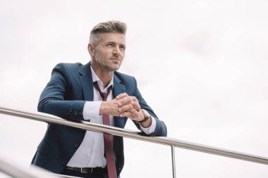 takım elbiseli işadamının seçici odak sıkıştırılmış elleri ile dışarıda ayakta