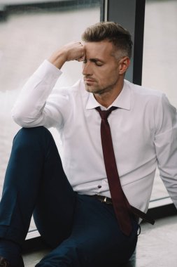 ofiste yerde oturan kapalı gözleri ile üzgün adam 